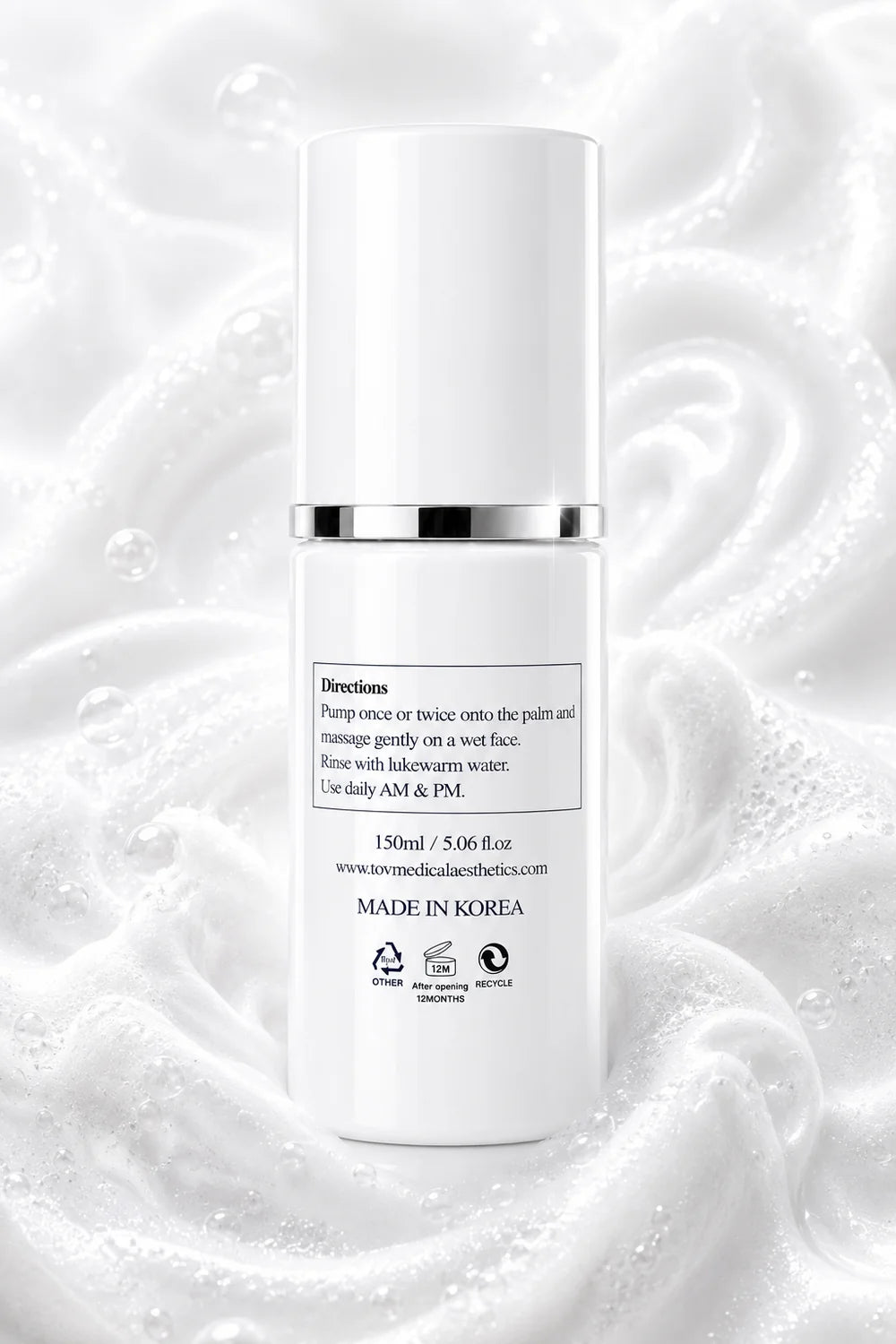 A white cylindrical skincare pump bottle with a silver collar band, centered against a background of white cream swirls and small bubbles. The bottle label contains black text starting with 'Directions'.